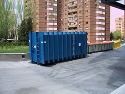 A large blue roll off dumpster outside an apartment complex in downtown Syracuse New York